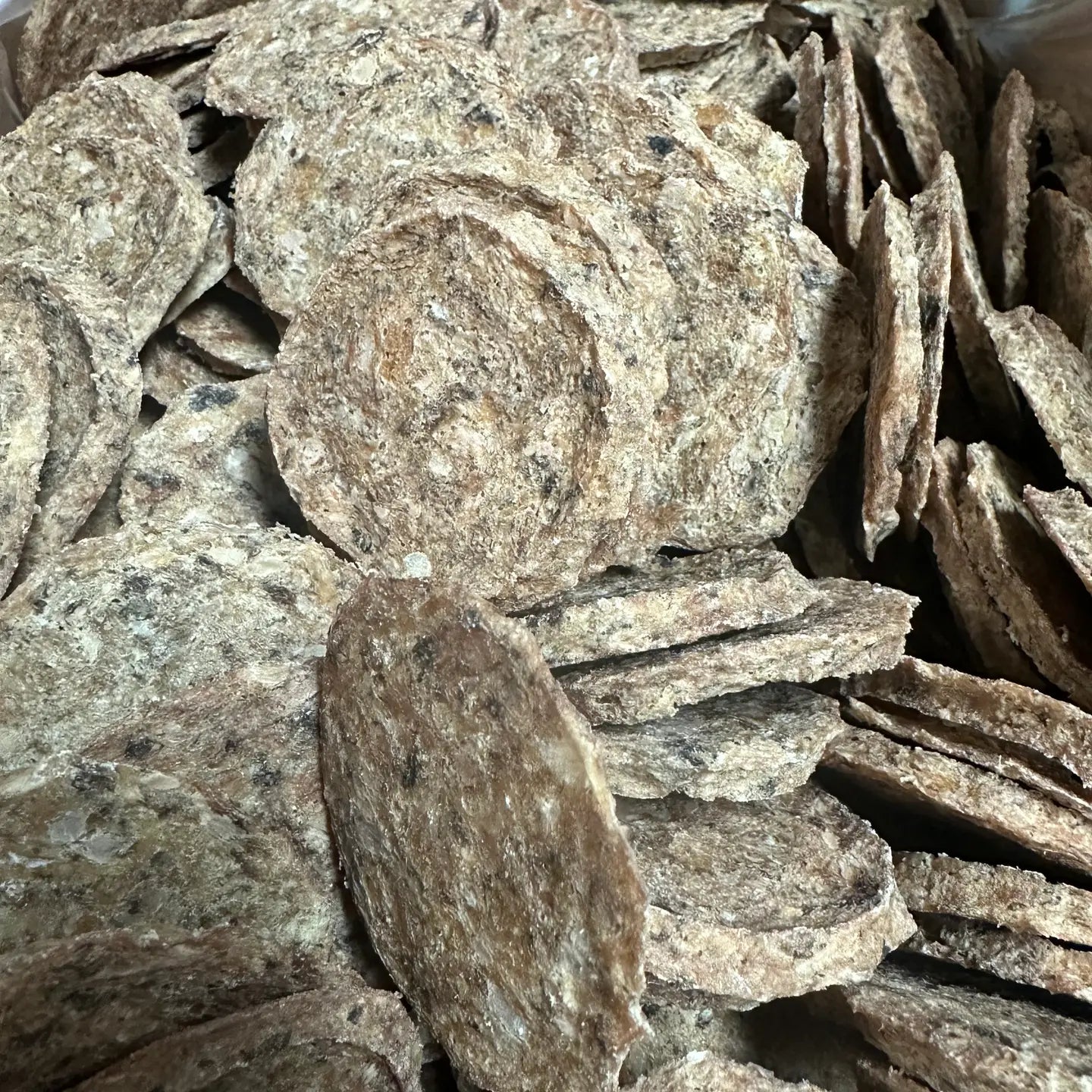 Close up of a pile of 4" diameter dehydrated dog treats