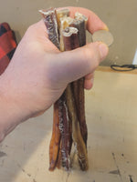 Bundle of 12-inch odorless bully sticks held in hand with quarter for size reference.  Thumbnail