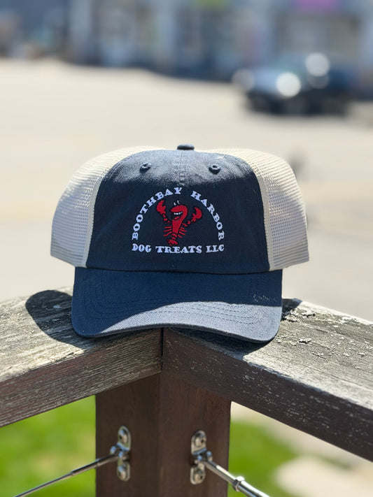 Navy and white Boothbay Harbor Dog Treats trucker hat with embroidered red lobster logo and mesh back