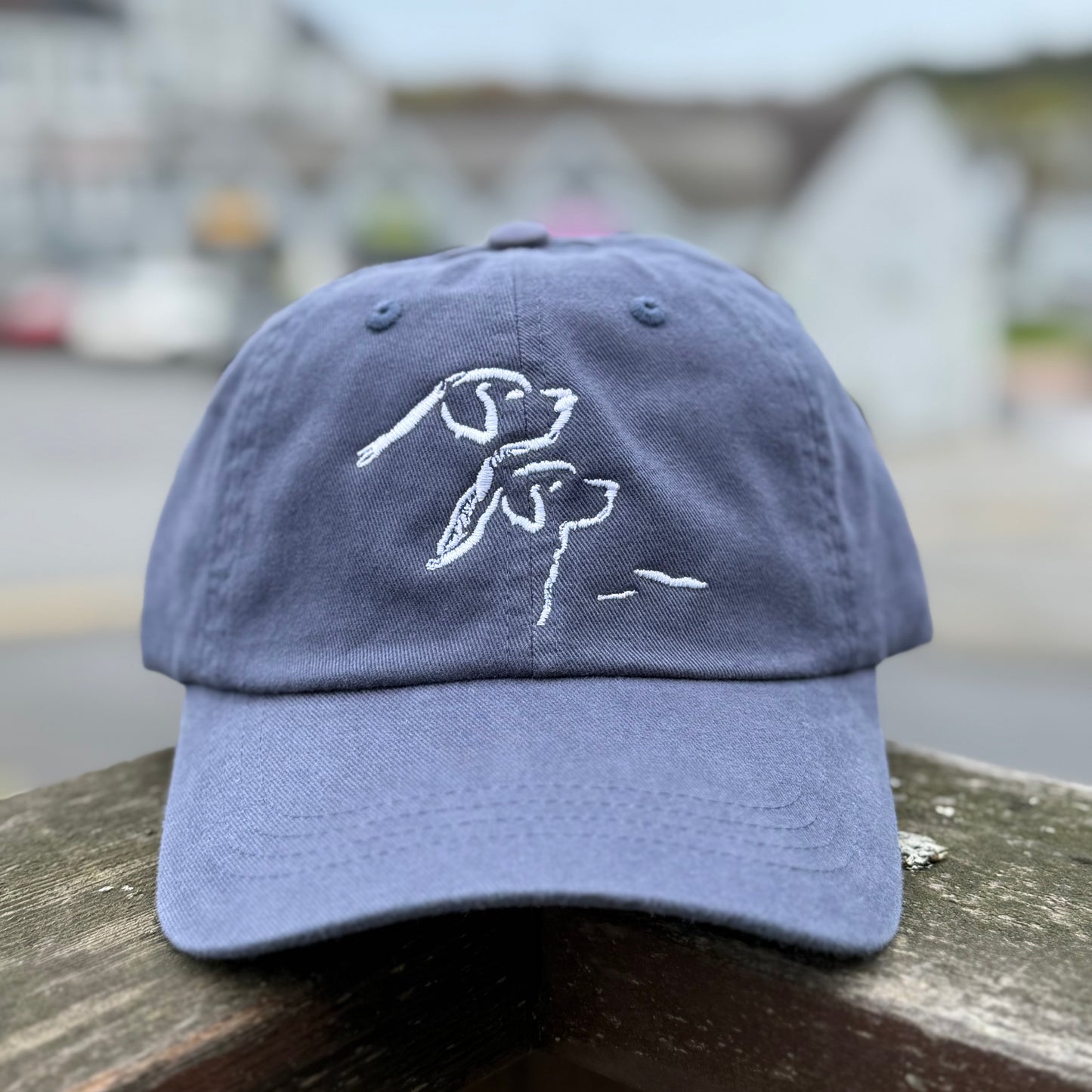Blue cap with white dog design on a blurred background