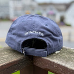 Blue cap with 'NaCl-y K9s' logo on a wooden surface outdoors Thumbnail