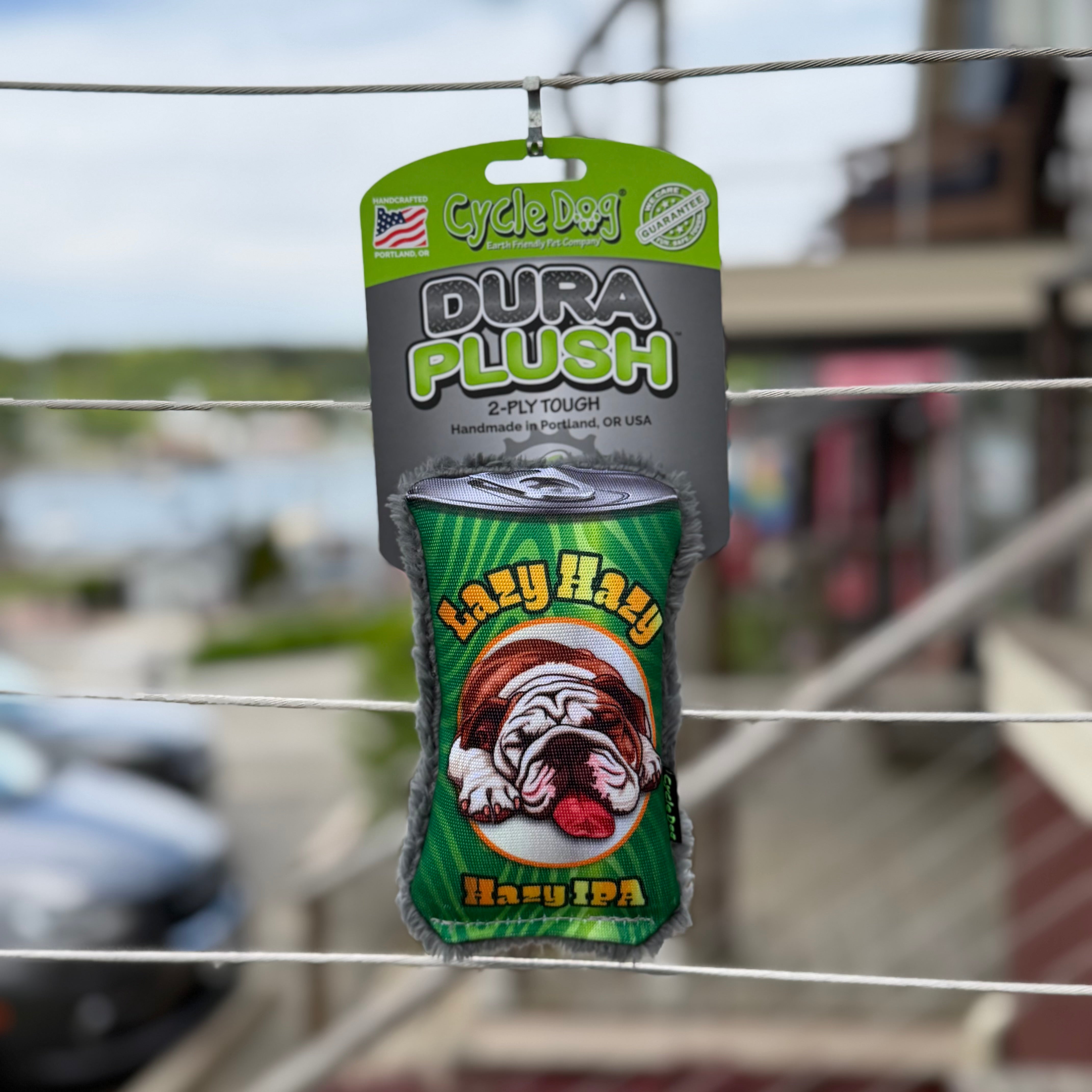 Cycle Dog Dura Plush beer can dog toy with" Lazy HazY Hazy IPA"  text and a lazy bulldog with his tongue hanging out.