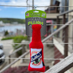 Red plush toy resembling a bottle labeled 'Bubba's Hot Sauce' on a metal railing with a blurred outdoor background. Thumbnail