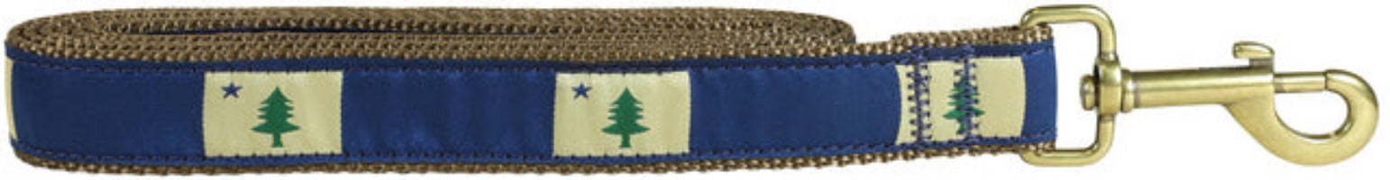 A beige dog leash with the Maine State Flag of 1820/1901 against a dark blue pattern ribbon with a brass trigger snap on a white background.