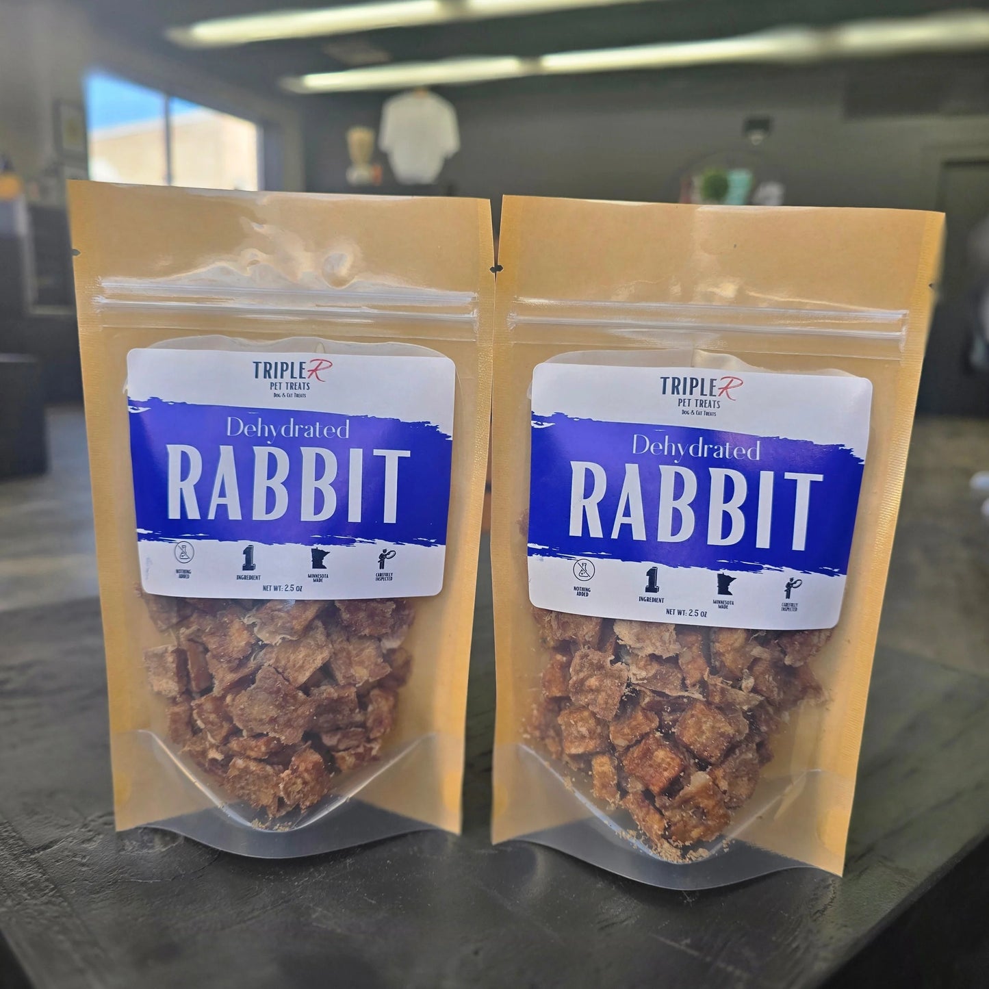 Two packages of dehydrated rabbit dog treats on a table.